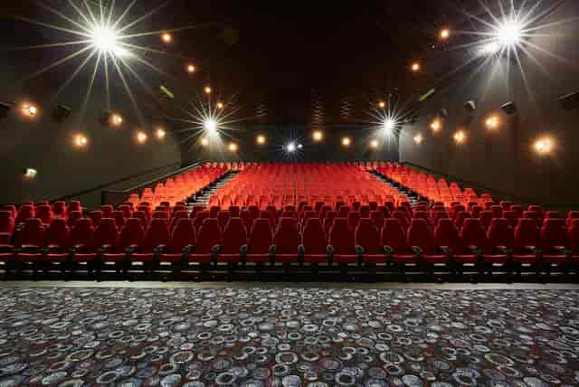 Large screen theater with red seating, ideal for corporate events and film screenings.