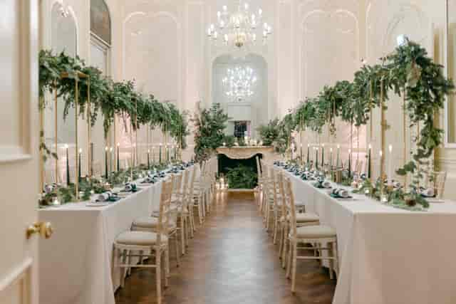 Formal Christmas party dining at Carlton House Terrace with elegant tall floral installations.