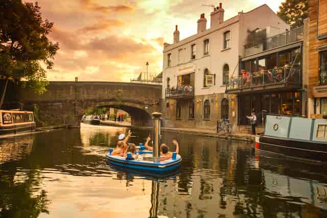 Floating hot tub at sunset on a canal, perfect for outdoor events and team-building.