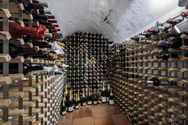Intimate wine cellar venue with organized racks for exclusive tastings and private dinners.