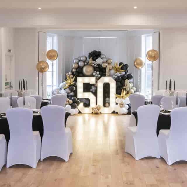 Ballroom at Linden House with elegant black, gold, and white 50th celebration setup.