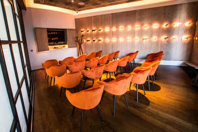 Private dining room with orange chairs, ideal for meetings and intimate gatherings.