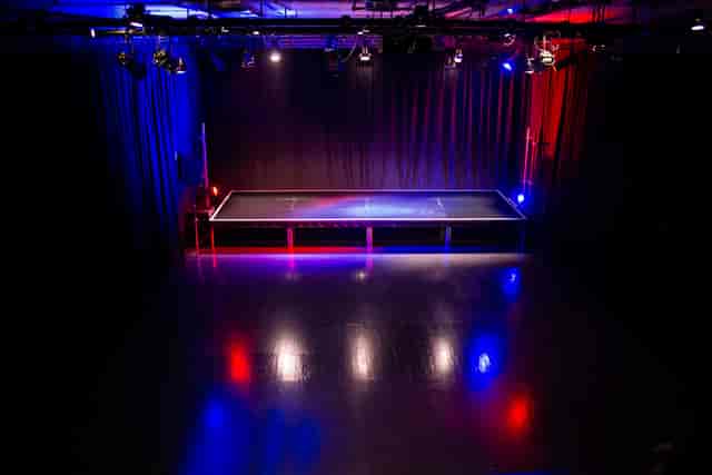 Versatile event space with elevated stage and dynamic red-blue lighting in Streatham.