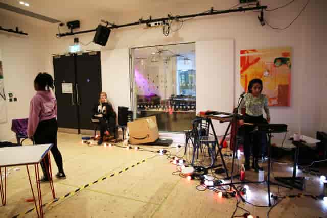 Dynamic event space in Streatham with musicians setting up for a creative gathering.