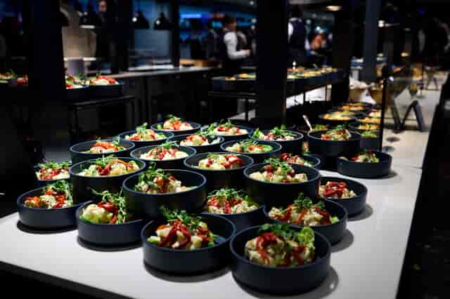 Buffet setup with vibrant salads at Tottenham Hotspur Stadium for formal events.