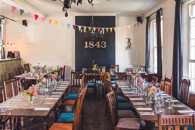 Charming event space at The Prince Albert Camden with rustic tables and floral decor.