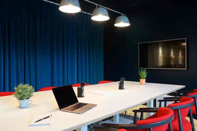 Modern meeting room with white table, red chairs for collaborative brainstorming sessions.