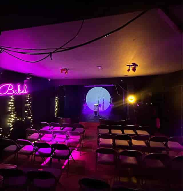 Cozy event space at Babel Art House with stage, ideal for performances and workshops.