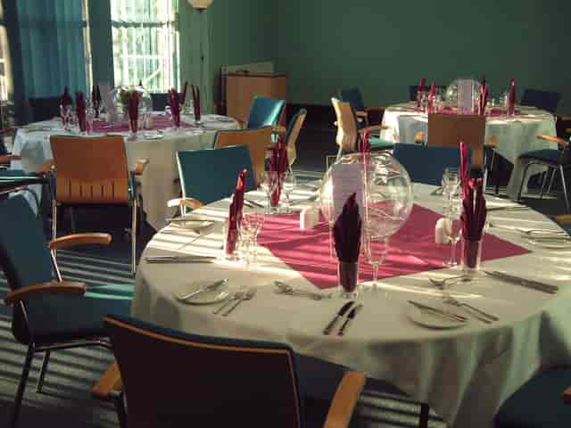 Elegant event space with round tables, ideal for corporate gatherings and banquets.