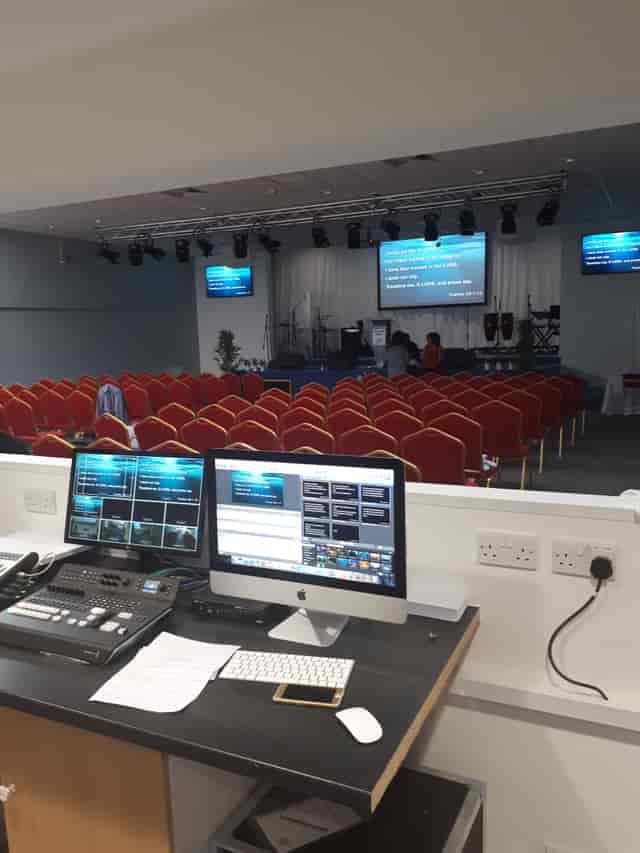 Business conference room with AV setup and red chairs for effective presentations.