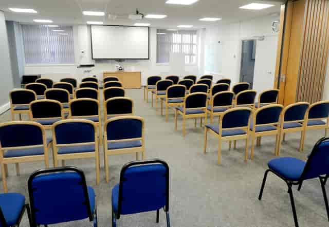 Meeting room with blue chairs, ideal for presentations and seminars in Bath Place.