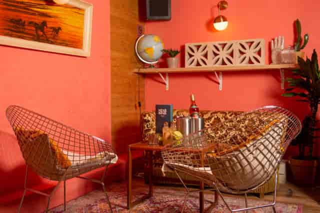 Stylish lounge in Studio 48 with coral walls, ideal for networking events and meetings.