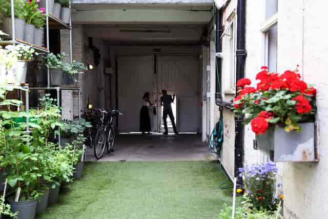 Charming venue entrance with dual doors for unique gatherings in lush greenery.