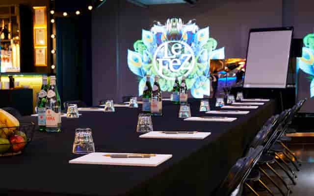 Meeting room at Le Club in Le Fez with black table, digital display, and wellness amenities.
