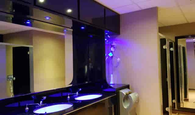 Modern executive lounge restroom with dual sinks for high-end events.