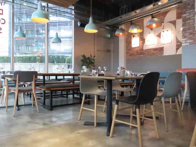 Modern dining space at KuPP, featuring wooden and metal furniture for casual events.