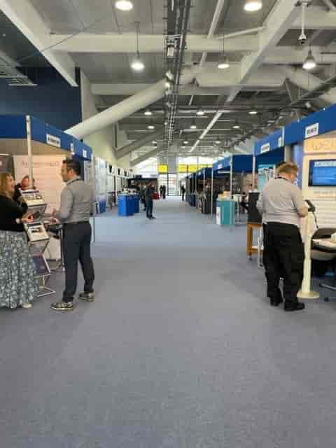 Grandstand at Newbury Racecourse, bustling exhibition hall for networking events.