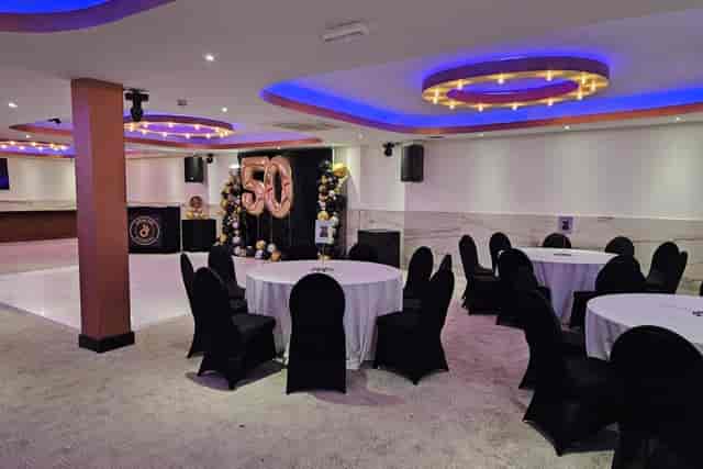 Black-and-white milestone celebration setup at Praba Banqueting Suite with ambient accent lighting.