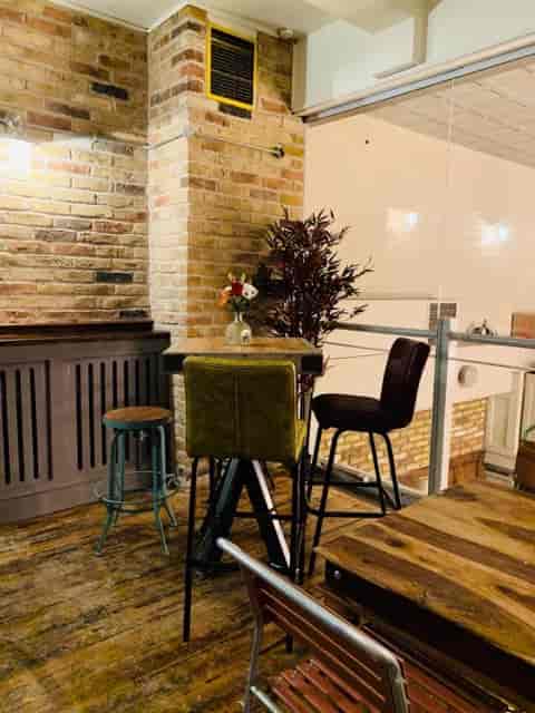 Cozy meeting space with stylish chairs and brick backdrop for informal gatherings.
