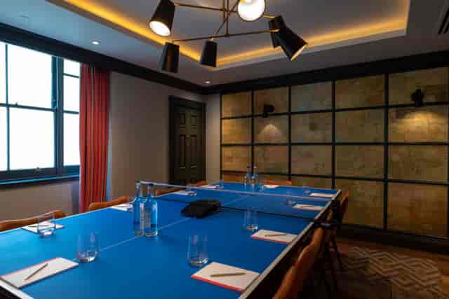Pitching Rooms at Home Grown Club, blue table setup for meetings and brainstorming.