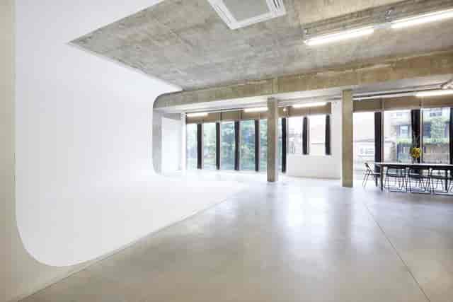 Versatile event space with white backdrop and natural light for corporate meetings and photo shoots.