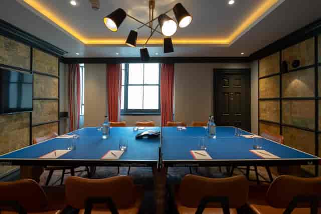Modern meeting room with ping pong table setup for creative brainstorming sessions.