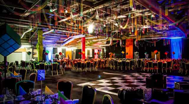Retro-themed gala at Edgbaston Stadium with checkerboard dance floor for corporate event hire.