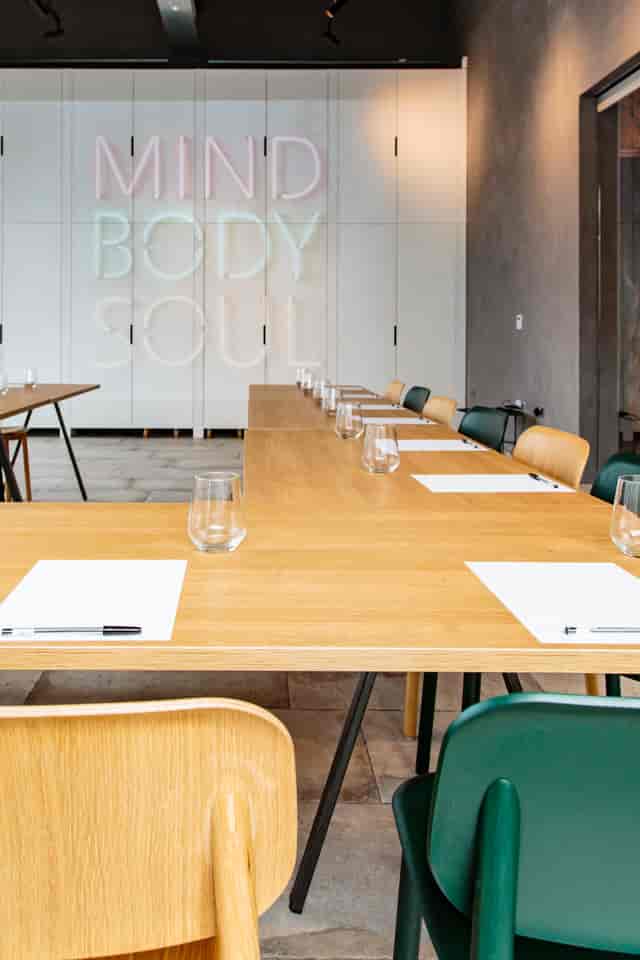 Modern meeting space with wooden table, ideal for corporate meetings and workshops.
