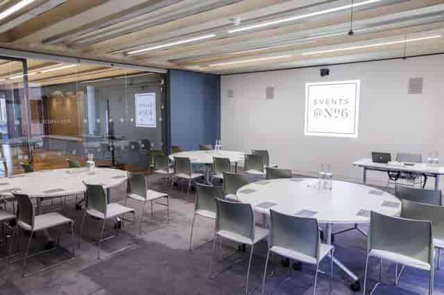 Modern meeting space with circular tables, ideal for corporate workshops and events.
