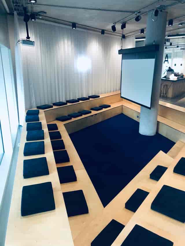 Modern tiered meeting space with cushions for workshops and brainstorming sessions.