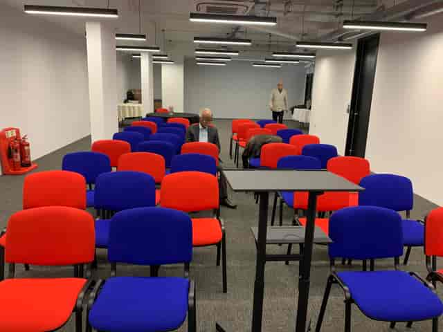 Vandon Rooms meeting space with red and blue chairs for events and networking opportunities.