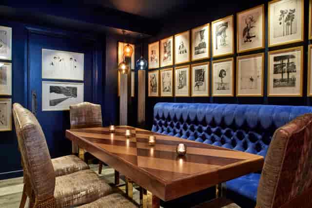Stylish meeting space with wooden table and plush seating at Andaz London Liverpool Street.