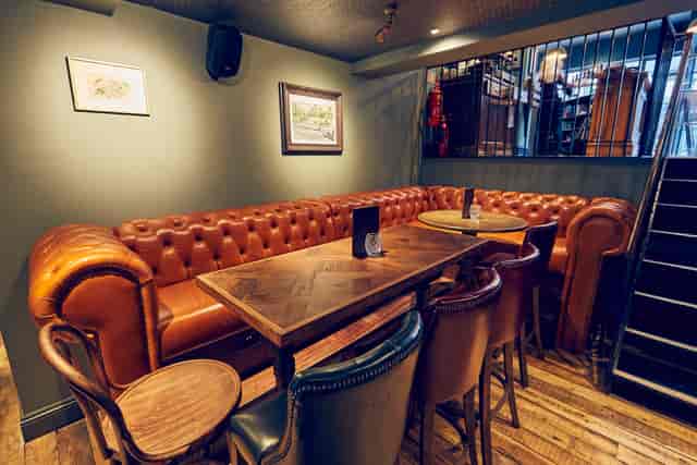 Cozy meeting space with leather sofa at East Putney Tavern for informal gatherings.