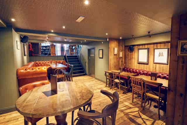 Cozy East Putney Tavern downstairs area with leather couches, perfect for casual events.