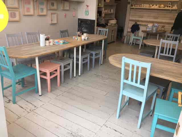 Cozy venue with wooden tables and colorful chairs for meetings and workshops.
