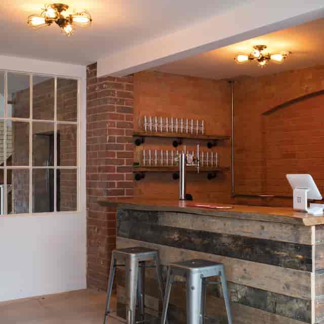 Stylish rustic bar with wooden counter, perfect for networking events and cocktail receptions.