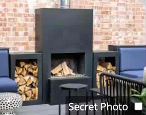 Industrial-chic breakout area with cozy fireplace, ideal for networking events and conferences.