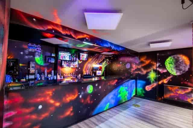 Vibrant space-themed bar with colorful murals for themed events and gatherings.