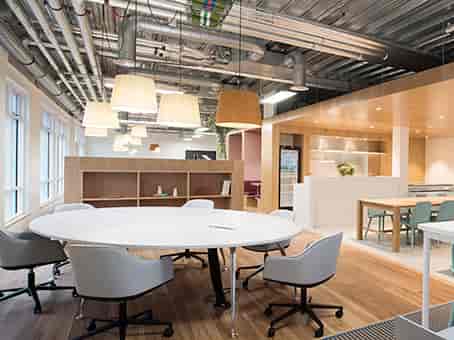 Modern open meeting space with circular table for collaborative brainstorming sessions.