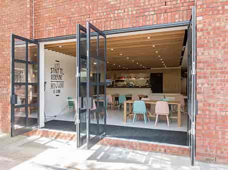 Modern event space in Jubilee House with pastel furniture, ideal for workshops and gatherings.