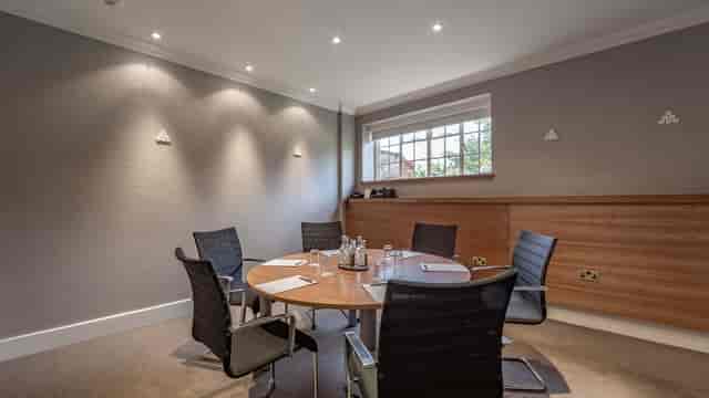 Modern meeting room with round table and ergonomic chairs at The Elvetham, Hampshire.
