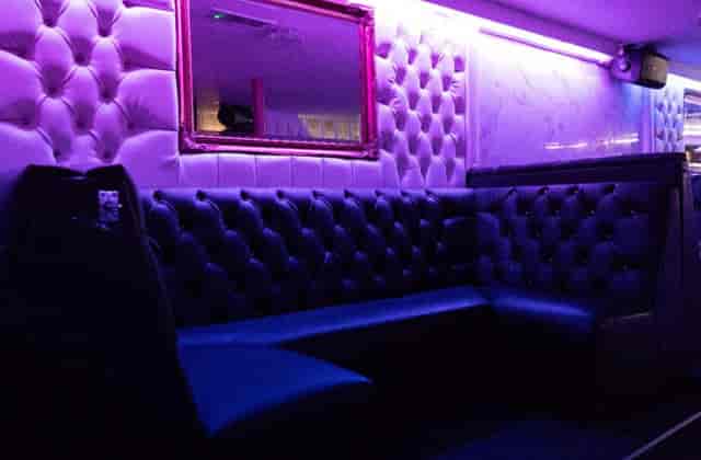 Stylish lounge with tufted seating and purple lighting for networking events at The Venue N10.