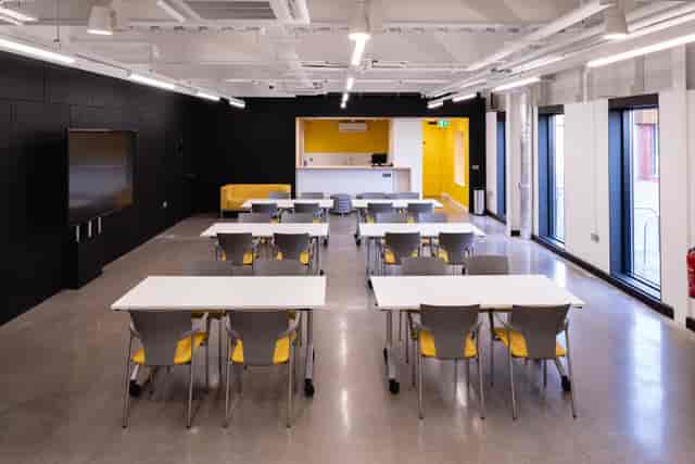 Modern meeting space with yellow accents, perfect for workshops and training sessions.