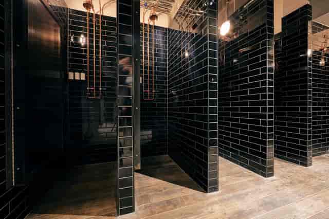 Modern black-tiled restroom in upscale event space, enhancing guest experience.