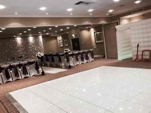 William Duesbury in elegant wedding venue with white tablecloths and purple accents.