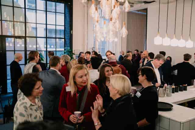 Vibrant networking event in Protein Studios with engaged attendees and warm lighting.