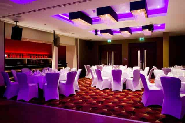 Elegant Christmas dinner setup with purple lighting at Holiday Inn Kensington.