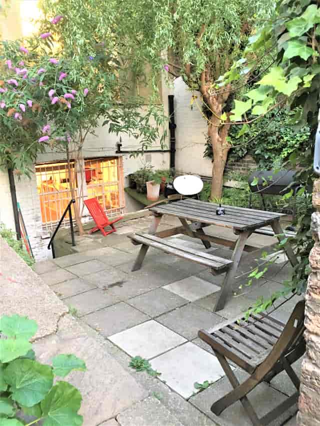 Charming outdoor venue in Dalston Den with rustic picnic table for networking events.