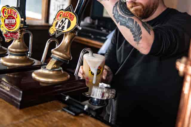 Bartender pouring draft beer at The Brewery Tap, enhancing event beverage service.