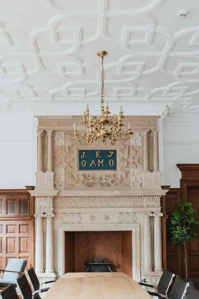 Elegant event space at The Brunel with grand fireplace and chandelier for upscale gatherings.